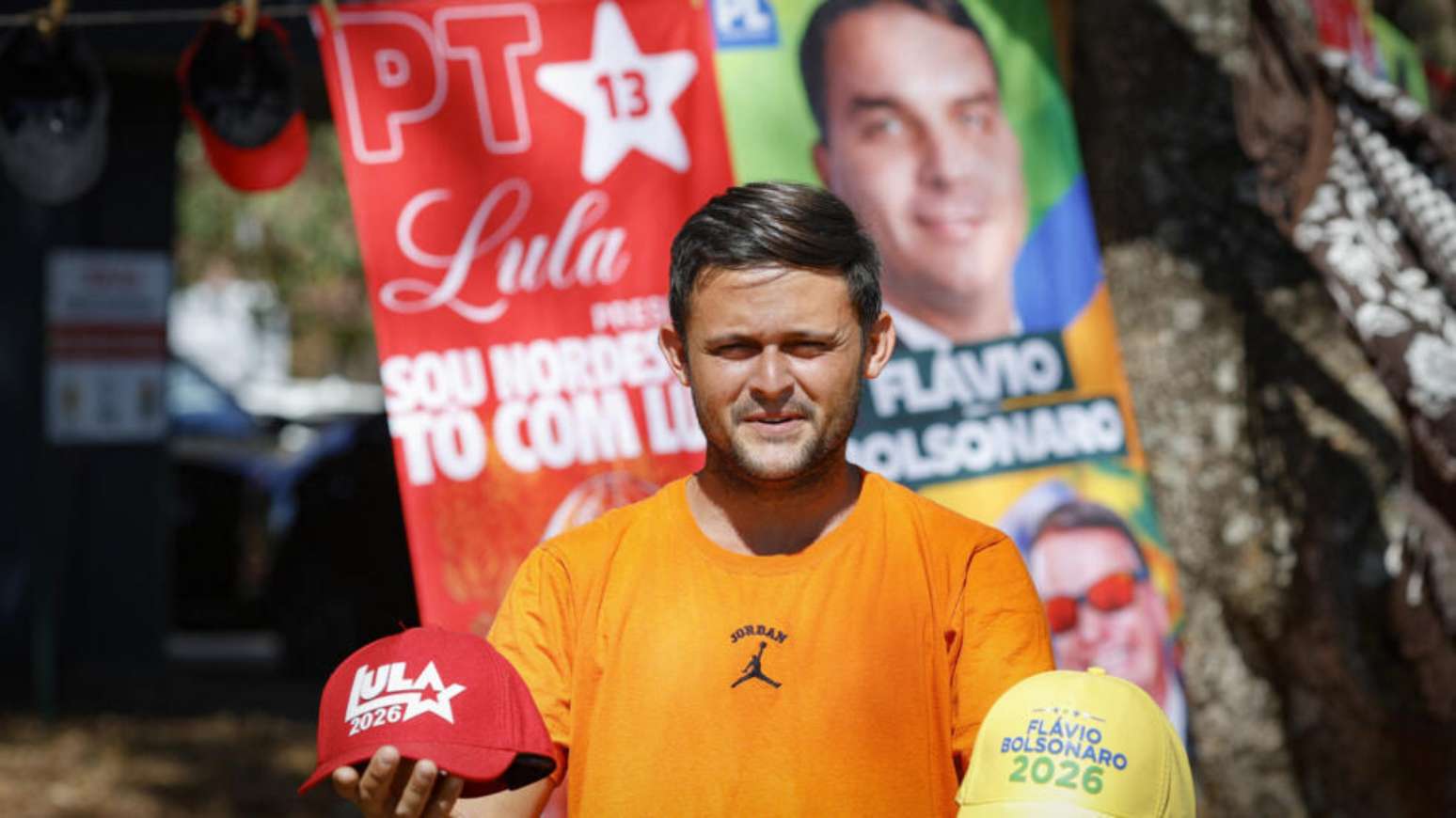 Um vendedor exibe bon&eacute;s &agrave; venda dos candidatos &agrave; presid&ecirc;ncia do Brasil, Luiz In&aacute;cio Lula da Silva e Fl&aacute;vio Bolsonaro, em um bairro residencial de Bras&iacute;lia, em 11 de setembro de 2026.