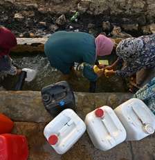 Mulheres recolhem água de fonte nas montanhas de Bizerte, Tunísia, em 21 de julho de 2026. Foto: AFP - FETHI BELAID / RFI