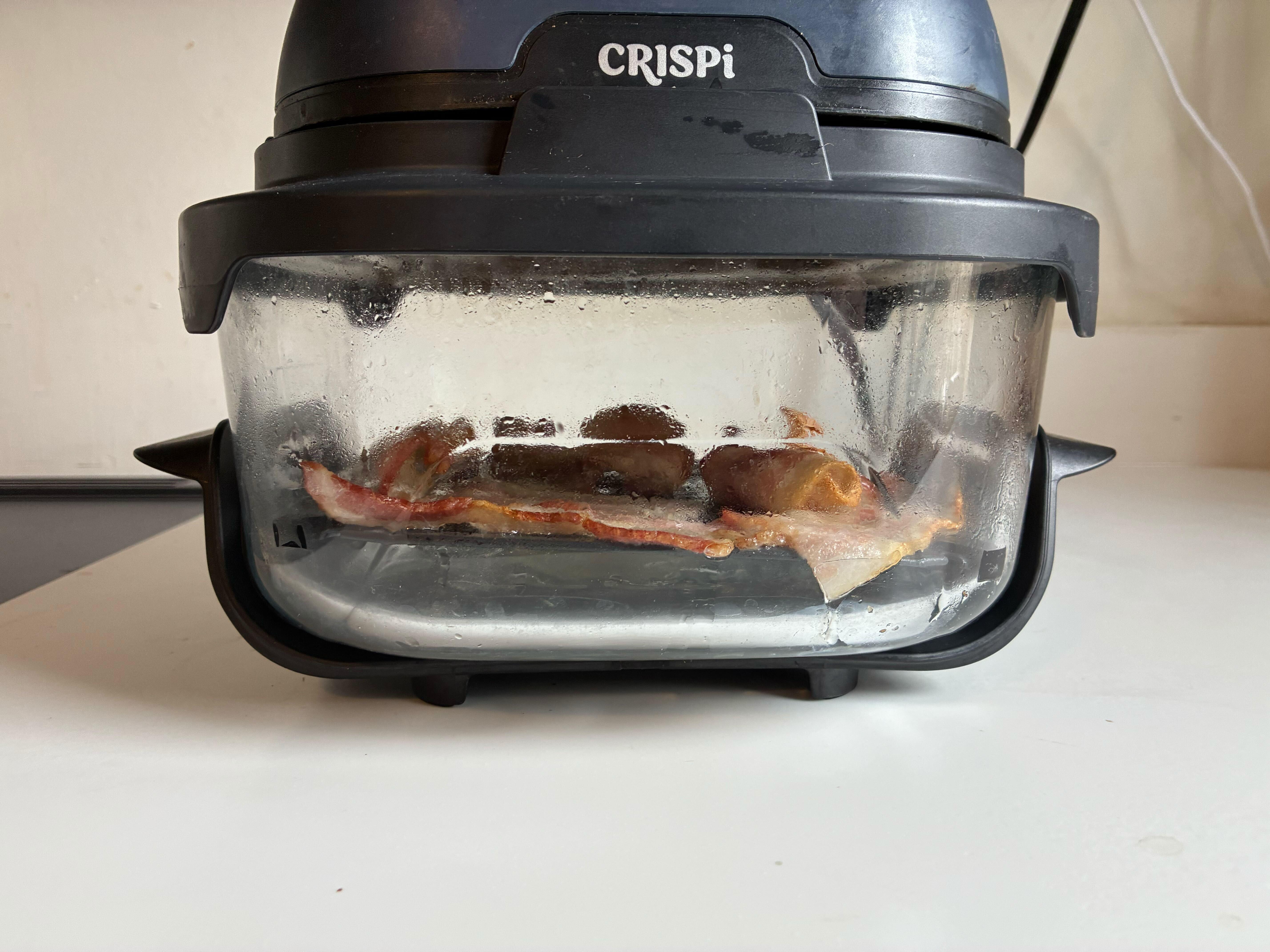 air fryer shot from the side with bacon on crisping tray
