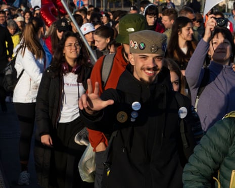 Group of young people waving banners and walking through a street