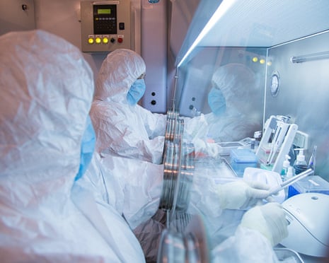 Research workers in protective suits in a lab