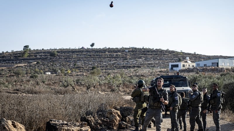 An Israeli soldier fires a tear gas grenade toward Palestinian olive pickers and orders them to leave the area during the olive harvest on October 17, 2026 in Abu Falah, West Bank. Yesterday, a group of Israeli settlers attacked Palestinians harvesting ol