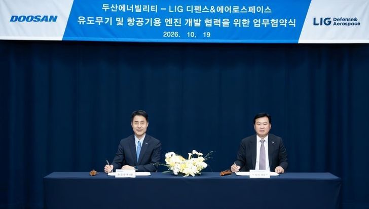 Doosan Enerbility's Power Service Business Group head Son Seung-woo, right, and LIG Defense & Aerospace's missile systems business division head Park Tae-sik sign a memorandum of understanding for joint guided weapon engine development at Doosan Tower in Bundang, Gyeonggi Province, Monday. Courtesy of Doosan Enerbility